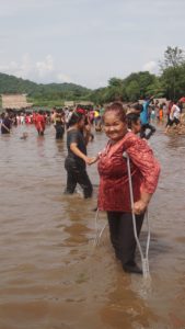 Woman on crutches at Thai Baptism