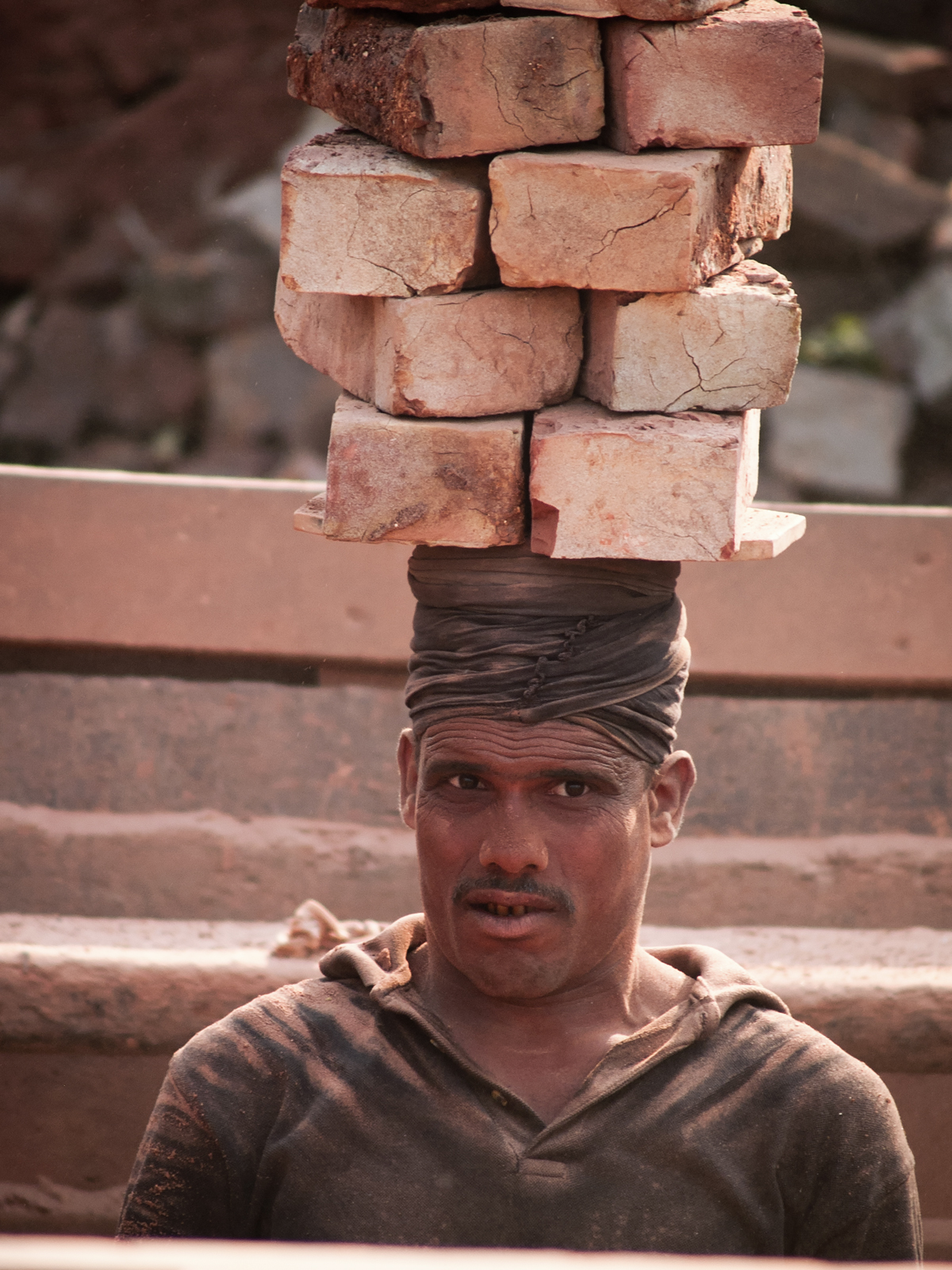 Brick carrier a Bangladesh man carrying bricks on his head